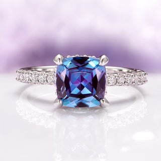 Ring with a large blue gemstone and smaller diamonds on a soft purple background
