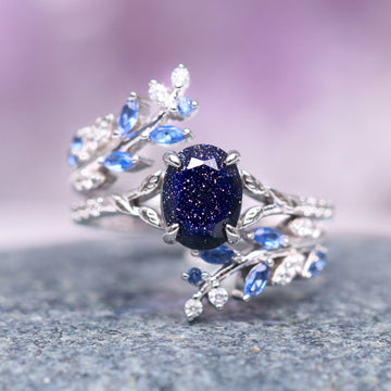 Starry Night & Sapphire Leaf Ring Set- 14K White Gold featuring a deep blue sapphire center stone surrounded by delicate leaf motifs with small blue and white gemstones, crafted by Aquamarise Gold from nature-inspired and starry night collections.