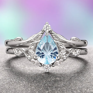 An exquisite Airee Aquamarine Ring Set featuring a fantasy-cut aquamarine centerpiece with leaf motifs on the band, set in 14K white gold.