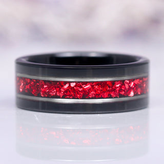 An 8MM black tungsten carbide ring with a crushed red garnet inlay, displayed against a neutral background.