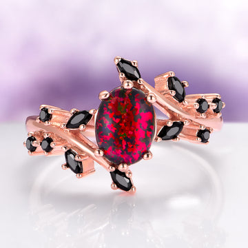 Black Fire Opal & Onyx Leaf Ring in 14K Rose Gold Vermeil features an oval black fire opal center stone with deep red flashes set in a rose gold vermeil band, accented with marquise and round black onyx stones.