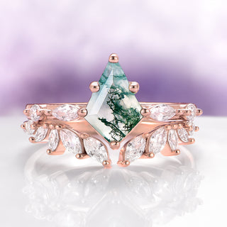 Rose gold ring with a green gemstone on a light purple background
