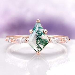 Ring with a green gemstone and rose gold band on a white background