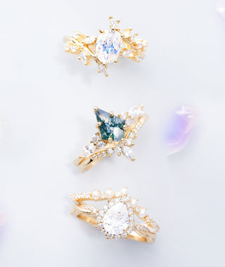 Three gold rings with gemstones on a light gray background