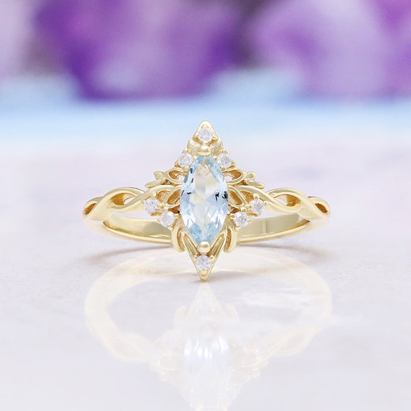 Siren Queen Marquise Aquamarine Lotus Engagement Ring in Solid 14K Yellow Gold by Aquamarise Gold, featuring a marquise aquamarine surrounded by delicate lotus-inspired gold and diamond accents.