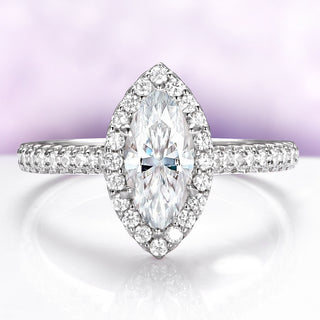 Diamond ring with a marquise-shaped center stone on a light purple background