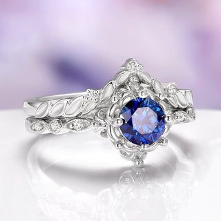 Silver ring with a blue gemstone on a white surface
