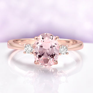 Everly Three Stone Oval Morganite Ring in 14K Rose Gold Vermeil by Aquamarise, featuring a 2 carat oval morganite center flanked by two simulated diamond accents in a classic setting.