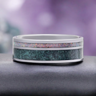 Moss Agate & Fire Opal Men's Wedding Band in Tungsten (8mm) by Aquamarise, resting on a grey stone to show the inlay detail.