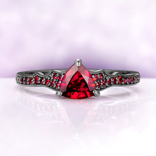 Trillion garnet center ring shown on its own, front view with garnet pavé along both shoulders