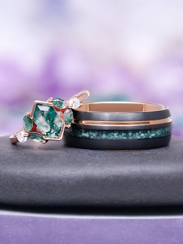 Two rings with green gemstones on a gray surface with a blurred purple background