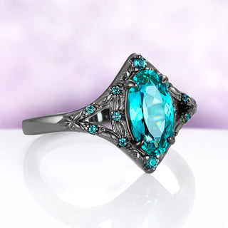 Angled view of the Nerida ring, showing the split shank with engraved leaves and small lab-grown spinel accents leading to the oval center