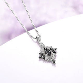 Angled view of the Nightbriar gray moissanite and black onyx pendant showing the eight-point starburst, cubic zirconia halo and polished bail