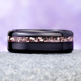 Crushed morganite black tungsten wedding band on granite, peach-pink flakes against the mirror-polished band