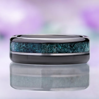 Front view of the 8mm tungsten band on a reflective surface with the off-center moss agate and black onyx inlays mirrored below