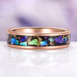 Rose gold ring with colorful gemstone inlay on a light background
