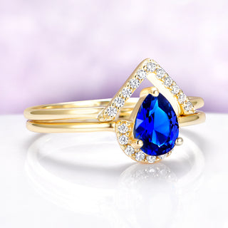 Gold ring with a blue gemstone on a white background