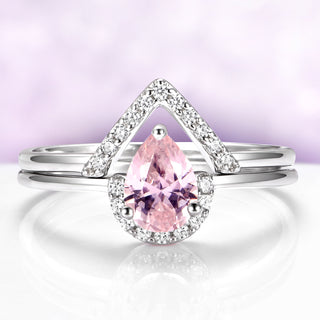 Silver ring with a pink gemstone on a light purple background