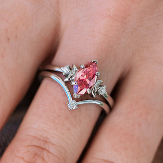 Silver engagement ring set with marquise cut pink moissanite center stone and diamond accents on hand
