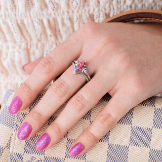 Silver engagement ring set with marquise cut pink moissanite center stone and diamond accents on hand