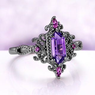 Angled view of the Ravenna cornflower sapphire ring, showing the beaded scrolls, the marquise sapphire at each end and the looped shoulders