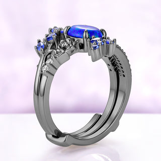 Side profile of the blue opal center ring nested inside the two arms of the black ruthenium wrap band