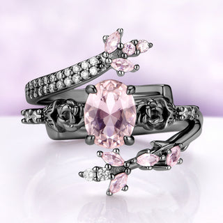 Morganite engagement ring set in black ruthenium — oval simulated morganite between sculpted roses with a pavé wrap band by Aquamarise