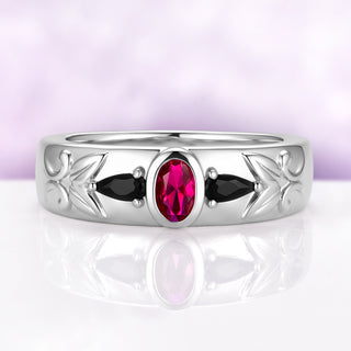 Men's 6mm sterling silver wedding band with a bezel-set oval lab-grown ruby between two black onyx pears and carved leaf shoulders