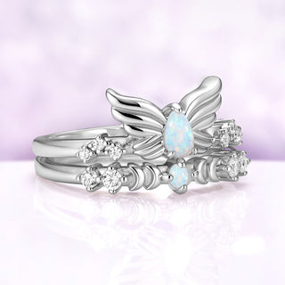 Angled view of the silver Selene wing ring and crescent moon band worn together, the moons sitting beneath the wings