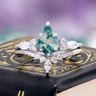 Skye Kite Green Moss Agate Ring by Aquamarise, styled on a dark celestial-print book cover.