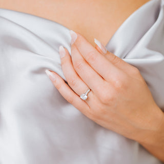 Twisted band diamond ring on a hand against a neutral background 