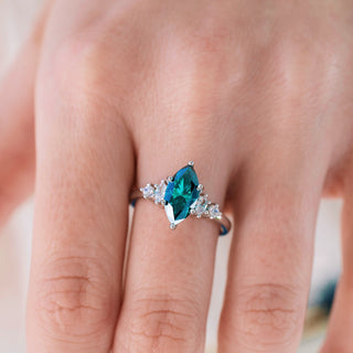 Ring with a blue gemstone on a finger against a neutral background