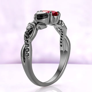 Side profile of the garnet and black onyx toi et moi ring in black ruthenium, the two strands of the band crossing below the setting