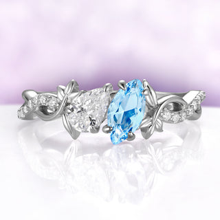 Toi Et Moi Simulated Aquamarine Leaf Vine Engagement Ring in Sterling Silver by Aquamarise, blue marquise beside a white pear stone between silver leaves