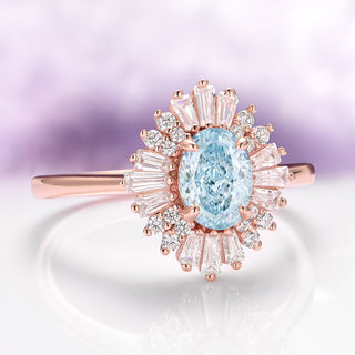 Rose gold ring with a blue gemstone and diamond accents on a light background