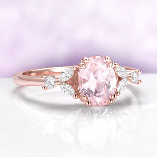 Rose gold ring with a pink gemstone on a light purple background