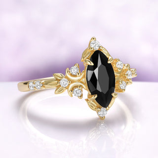 Angled view of the onyx against warm gold, showing the crescent moons and pave shank