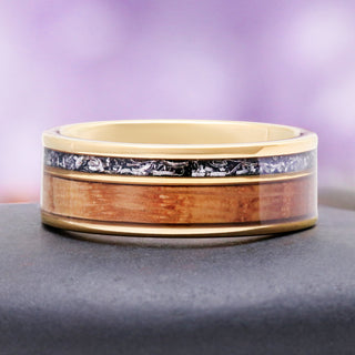 Whiskey barrel meteorite band on slate, showing the warm grain of the oak against yellow gold