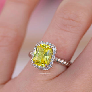 Close-up of hand wearing a ring with a yellow gemstone 