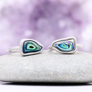 Two abalone paua shell rings side by side showing how the natural shell color and pattern vary per ring