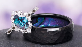 Black ring with a blue heart-shaped gemstone on a gray surface