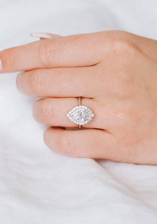 Hand wearing a silver ring with a diamond on a white background
