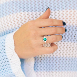 Emerald Engagement Ring Round Emerald Halo Ring overtextured blue and white background 