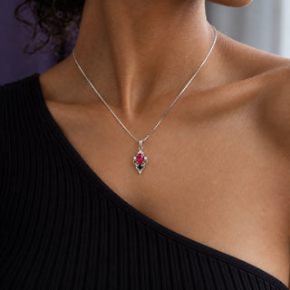 Model in a black one-shoulder top wearing the Carmilla lab-grown ruby and black onyx pendant necklace in sterling silver