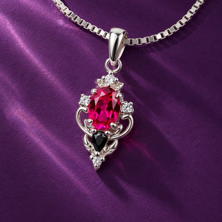 Carmilla lab-grown ruby and black onyx pendant necklace in sterling silver on a box chain over deep red satin