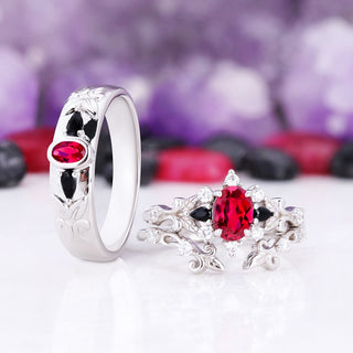 Angled view of the Carmilla ruby and black onyx his and hers rings showing the carved leaf detail on the men's band