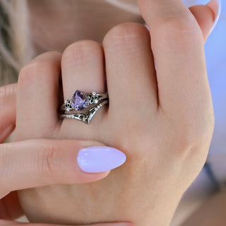 Close-up of the pear alexandrite Celtic knot ring and chevron band stacked on the finger