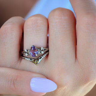 Celtic knot alexandrite ring set in black ruthenium worn on a model's hand