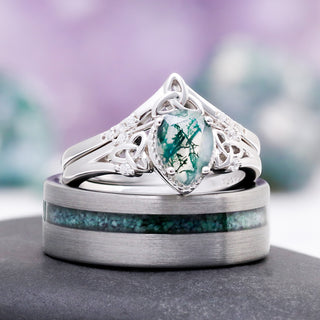 The Celtic knot moss agate ring set resting on the men's off-set moss agate tungsten wedding band