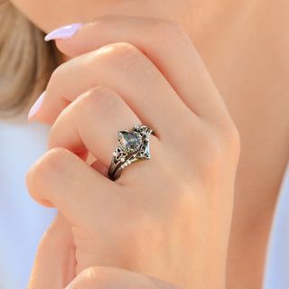 Celtic knot mystic topaz ring set in black ruthenium worn on a model's hand
